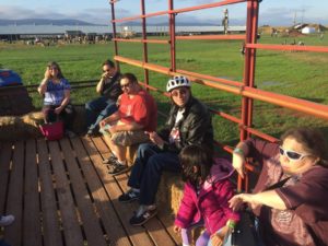 Hay ride from back to front is Natalie sitting next to her husband whom is sitting in the corner. Next to him is Zach, sitting close to Zach is Michael., then Paige then the font right is Roz