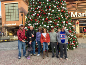 Group photo in front of the Christmas tree, from left to right is Michael, Paige, Mark, Natalie, Katie, Roland, Melissa behind Missy 