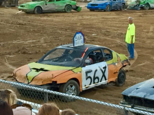 Car that looks a bit beat up, that is half yellow and half orange, yellow at top and orange on the bottom, there's a pointy thing at the top that says 56x and on the side of the car. 