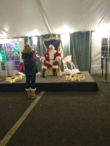 Santa in chair up on a stage, centered