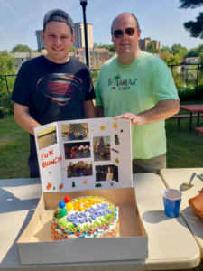 (Right to left) David and Mark standing behind a Fun Bunch poster and cake 